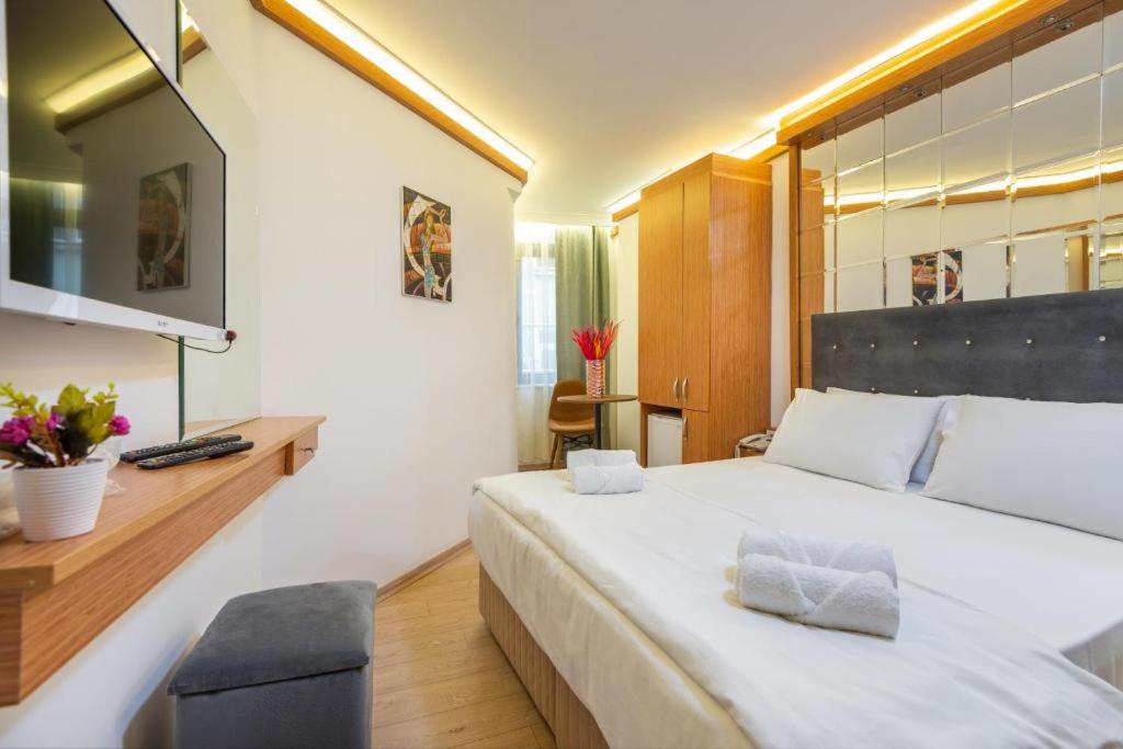 a bedroom with a large white bed and a desk at Viva Butik Apart in Istanbul