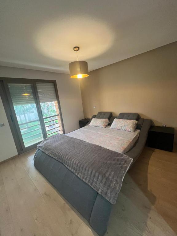 a large bed in a bedroom with a large window at Beach appartement in Kenitra