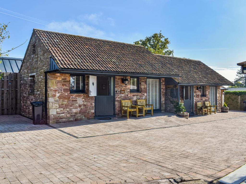 een stenen cottage met een patio ervoor bij Oak - Uk50462 in Alvington