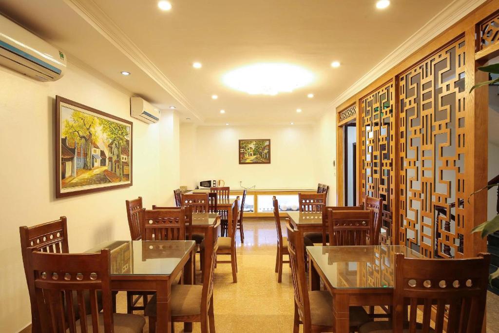 a restaurant with tables and chairs in a room at Bạch Dương Hotel Hà Nội in Hanoi