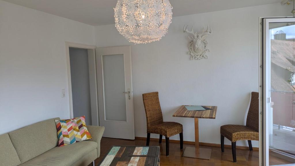 sala de estar con sofá, sillas y lámpara de araña en Herzstück, en Gengenbach