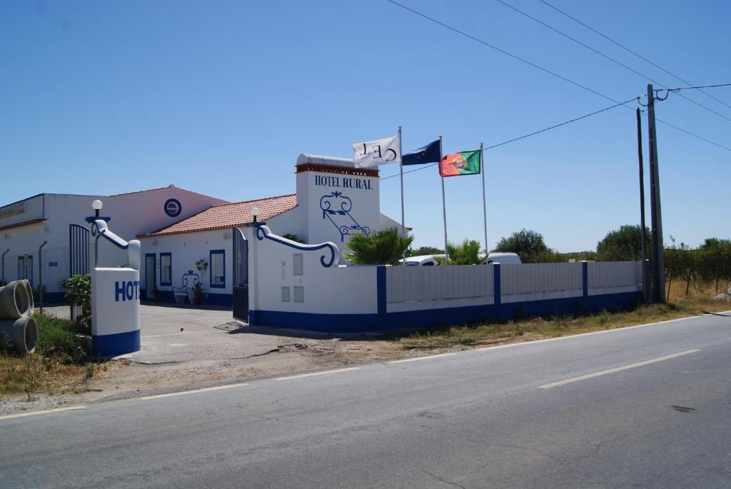 a building with a fence next to a street at Reguengos Hotel in Reguengos de Monsaraz