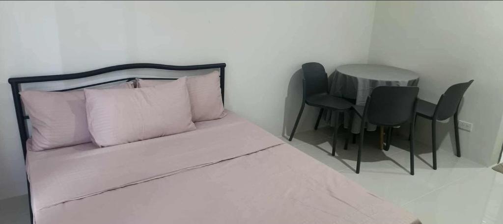 マンダウエ・シティにあるLei's Abodeのベッドルーム(ベッド1台、テーブル、椅子付)