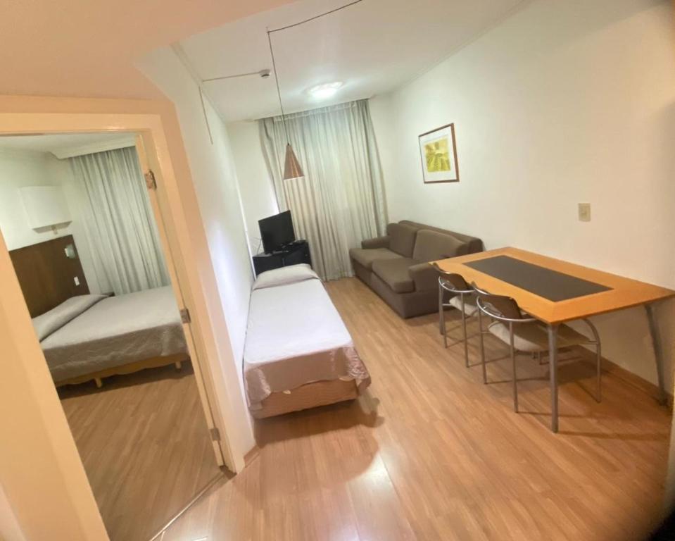 un petit salon avec un canapé et une table dans l'établissement Guará Inn Flat Service, à Guaratinguetá