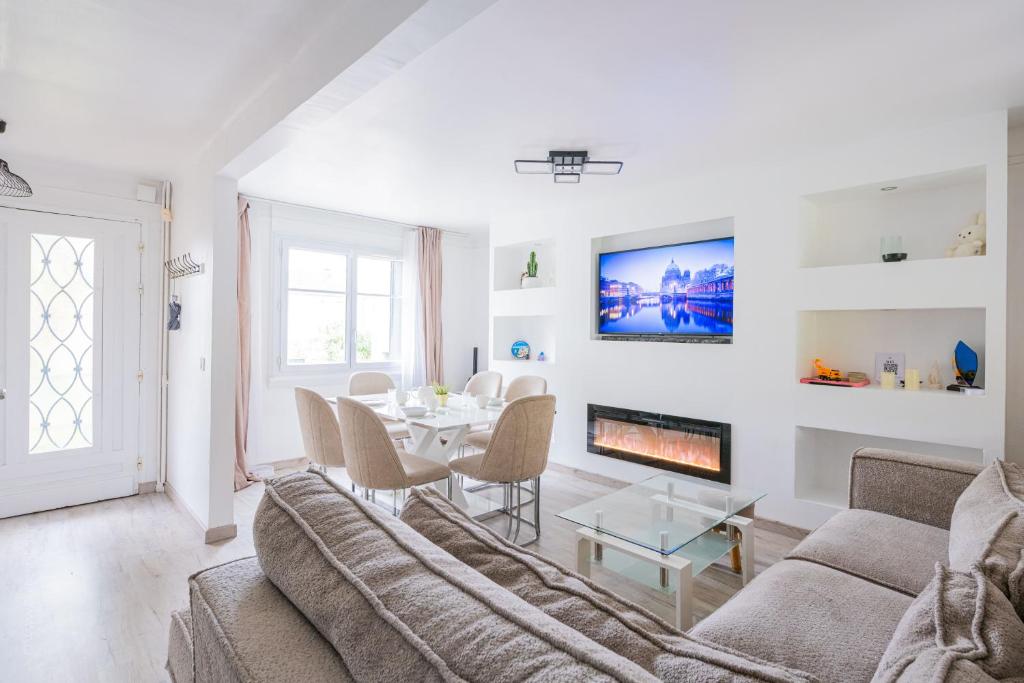 a living room with a couch and a table and a fireplace at Maison Cosy - Tout équipé - à 15 min de La défense in Argenteuil
