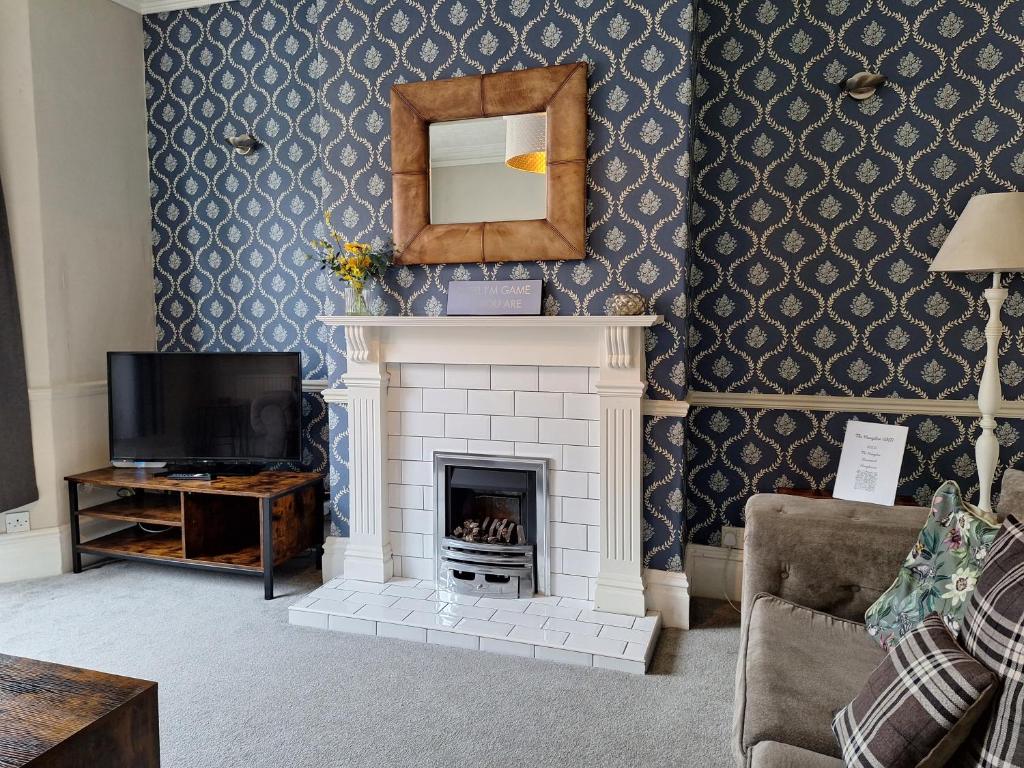 ein Wohnzimmer mit Kamin und Spiegel in der Unterkunft The Hampton Beautiful 3 Bedroom House with Conservatory & Garden in Scarborough