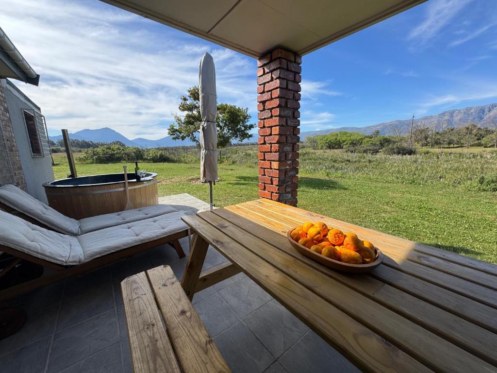 a bowl of fruit on a wooden table on a patio at Tulbagh Tiny Homes in Tulbagh