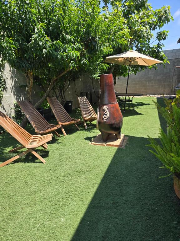 Rosarito BeachにあるLa casa rusticaの椅子と傘の隣に置かれた大きな花瓶