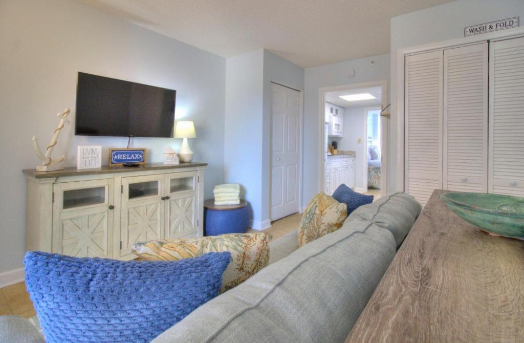 a living room with a couch and a flat screen tv at Verandas - 808 in Myrtle Beach