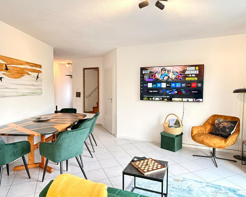 a dining room with a table and chairs and a tv at Femo S & E Apartments 2 Bäder eigener Eingang in Burbach