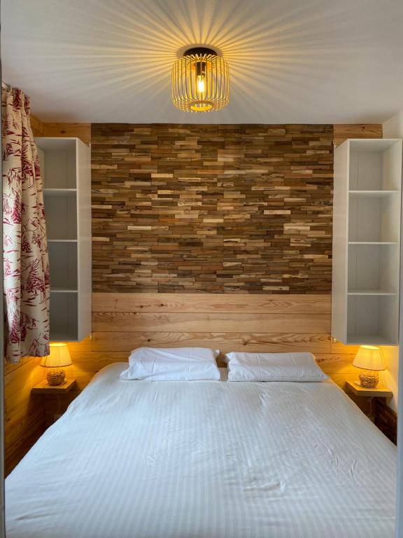 a bedroom with a large white bed with two lamps at Appartement Termignon Val Cenis in Termignon