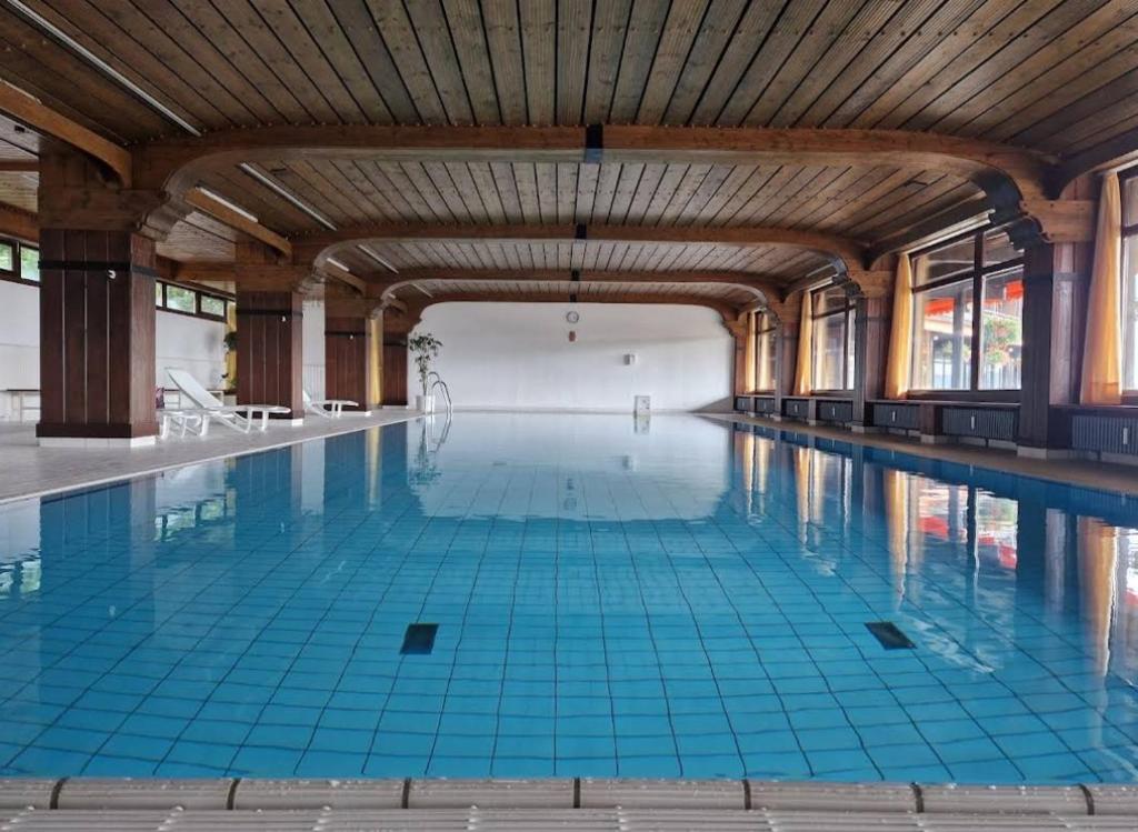a large swimming pool with blue tiles on the floor at Foresty Appartement in Schonach