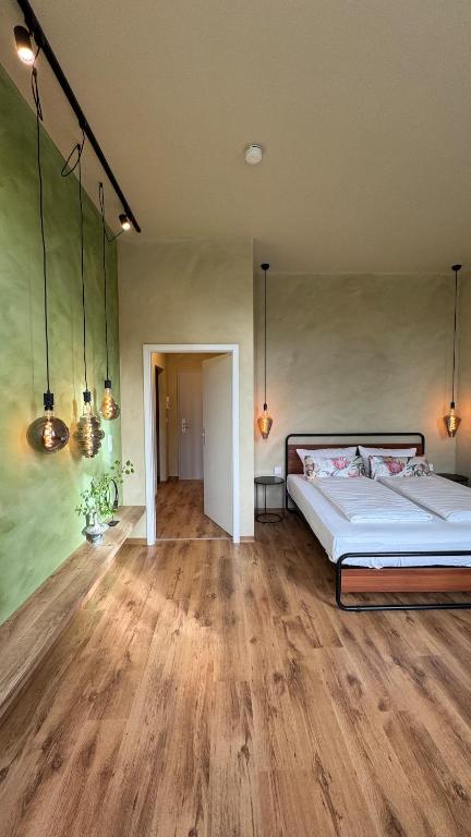 a bedroom with a bed and a wooden floor at Nordic Zen Loft mit Garten in Magdeburg