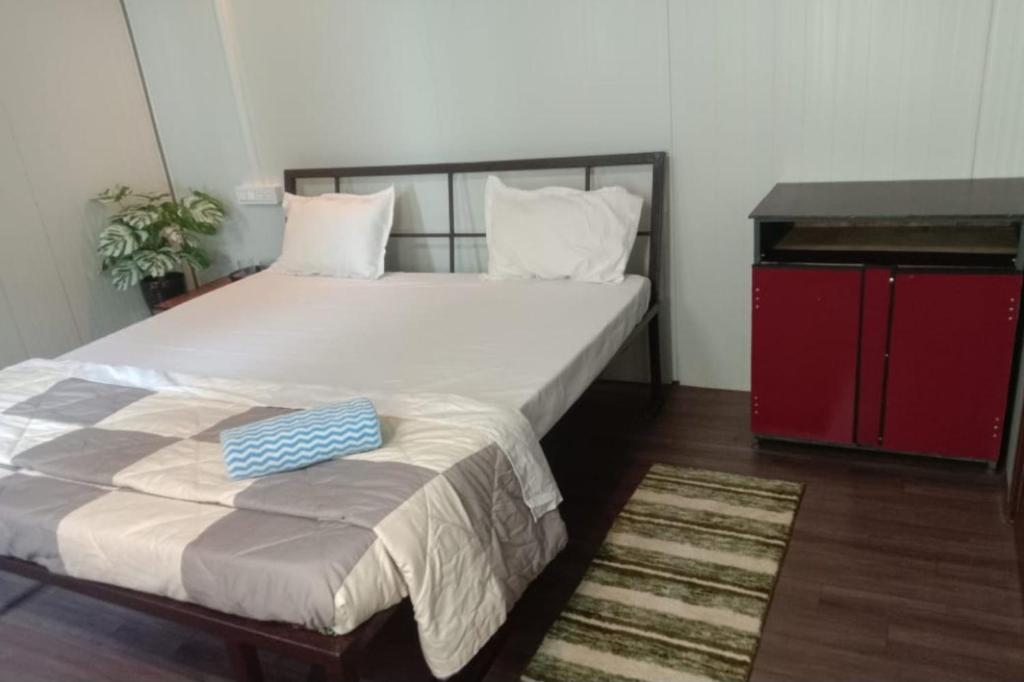 a bedroom with a large bed and a red cabinet at Johmena Serena Homestay in Kāsarkod