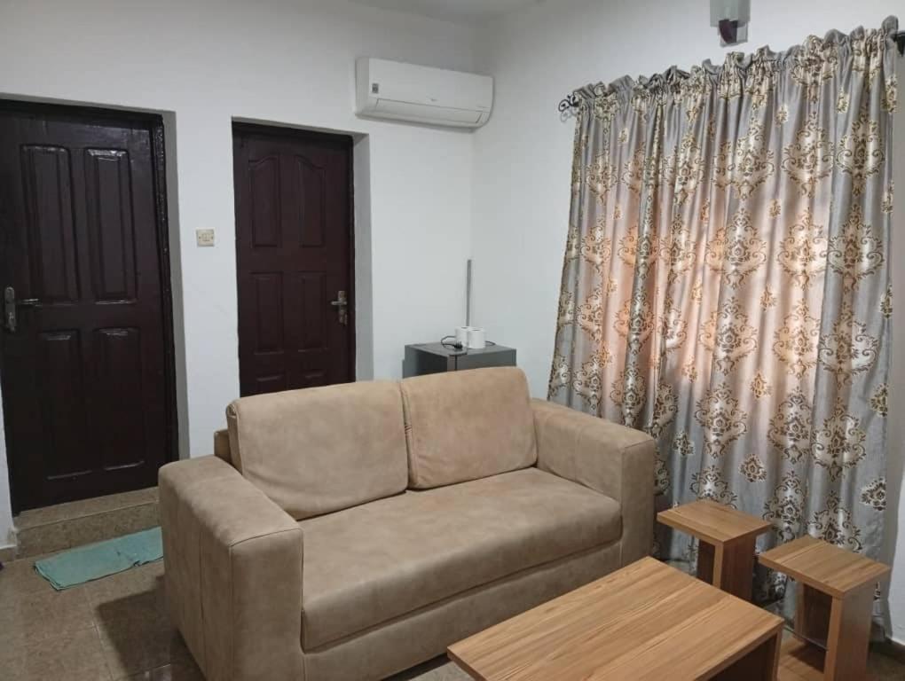 een woonkamer met een bank en een raam bij Entire 1 Bedroom flat in Lagos in Orile