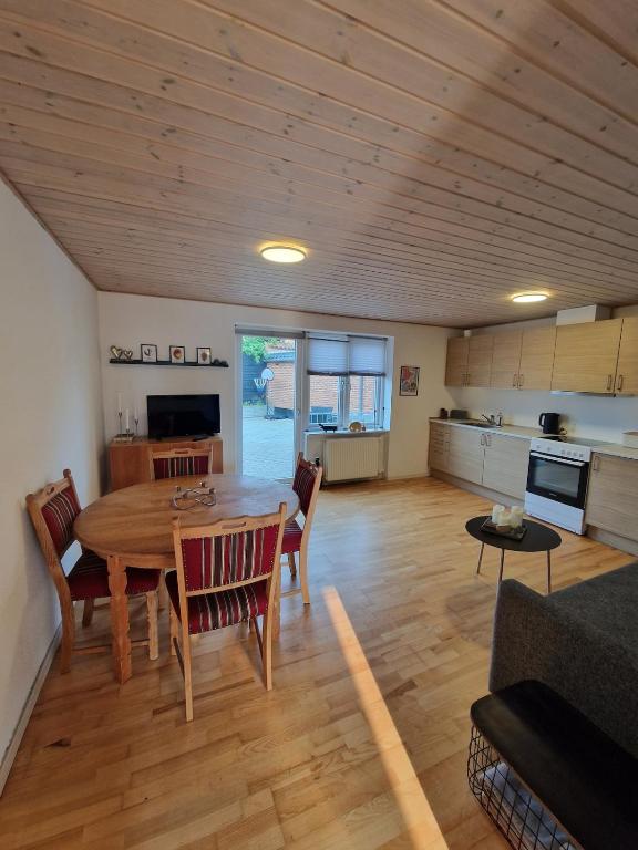 a living room with a table and a kitchen at Lejlighed i Gråsten in Gråsten