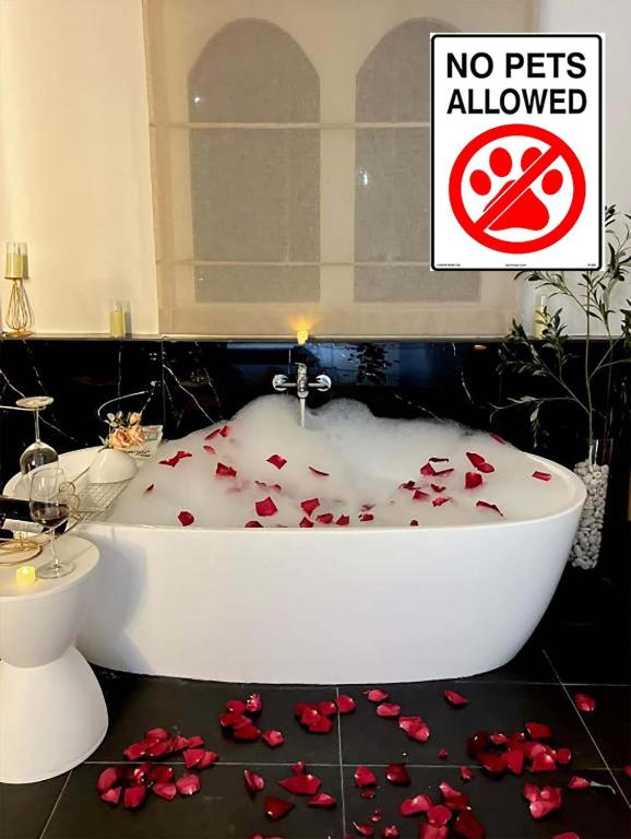 a bathroom with a bath tub with red roses on the floor at 24Rooms นครสวรรค์ in Nakhon Sawan