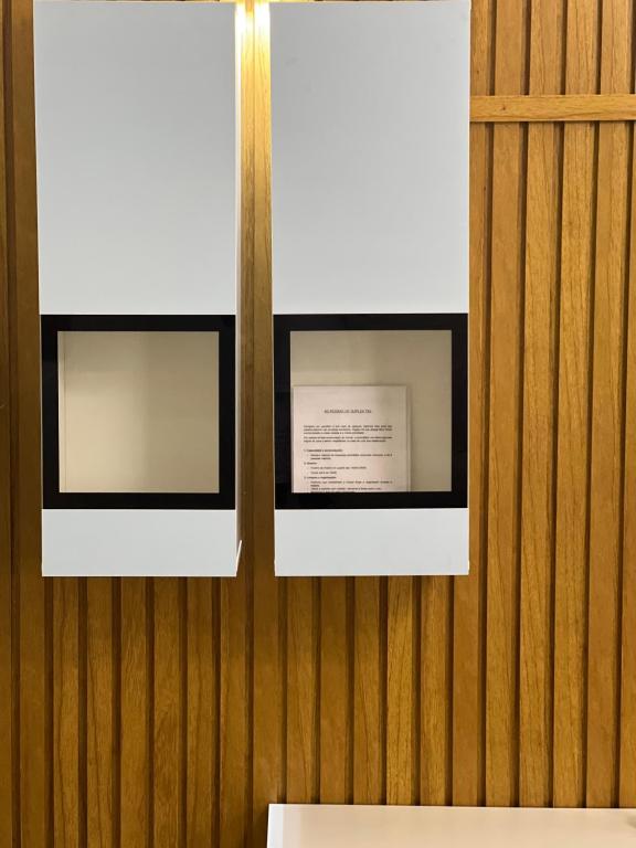 two framed photographs on a wooden wall at Duplex tx4 in Bissau