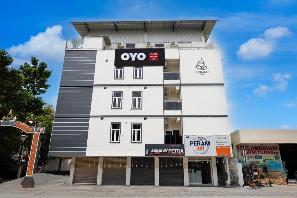 Un edificio blanco con un cartel en él. en Hotel O Peram INN, en Tirupati
