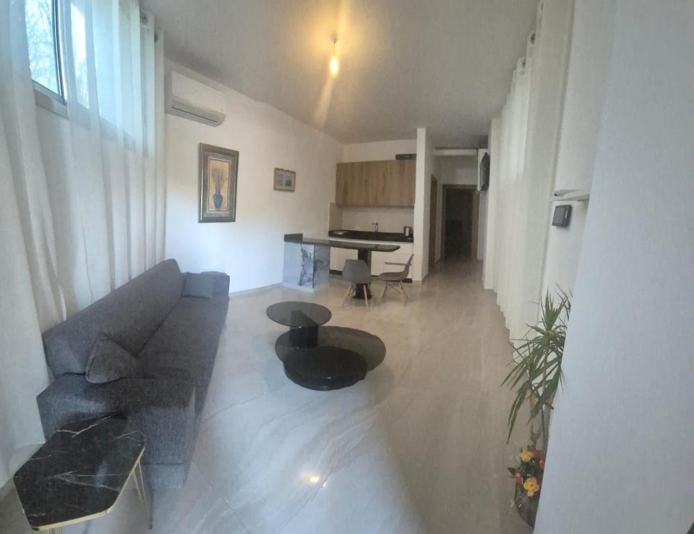 a living room with a couch and a table at Aley Pilot Residence in Al Qammāţīyah