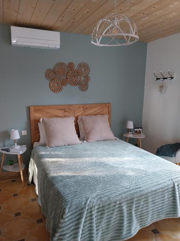 Un dormitorio con una cama grande con cabecero de madera. en Mon petit coin de paradis, en Coursan