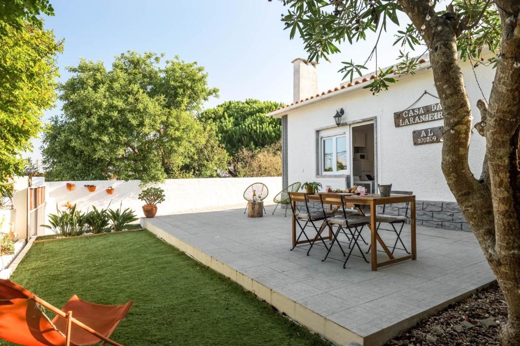 a patio with a table and chairs in a yard at Casa das Laranjeiras in Alfarim