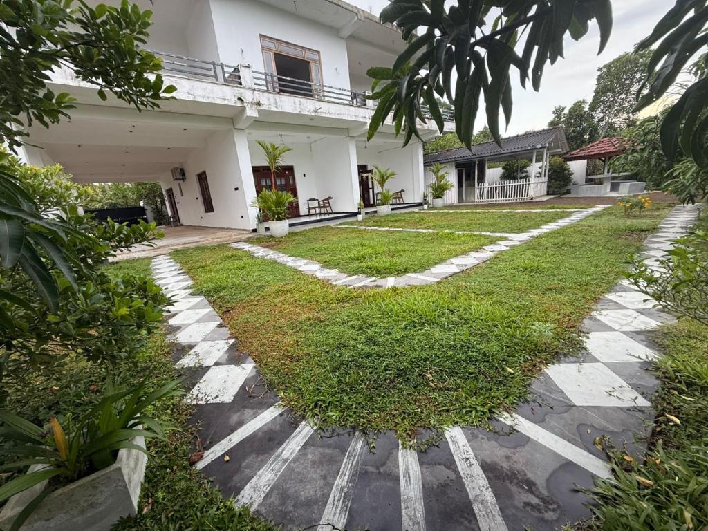 a house with a walkway in front of a yard at Natural Lake Down South in Habaraduwa