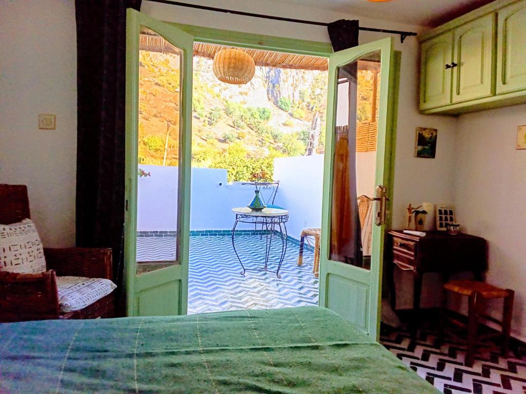Schlafzimmer mit einer Tür, die auf eine Terrasse führt in der Unterkunft Dar SBAA in Chefchaouen