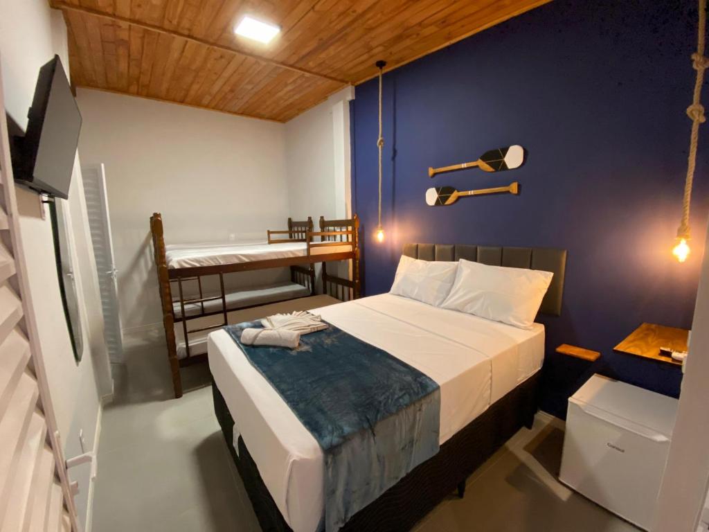 a bedroom with a bed and a room with two bunk beds at Ilha Grande Trip in Abraão