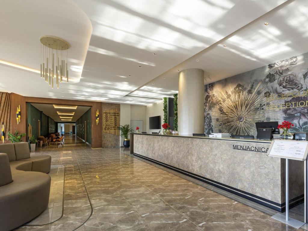 a lobby of a hotel with a reception counter at Movenpick Resort and Spa Fruske Terme in Vrdnik