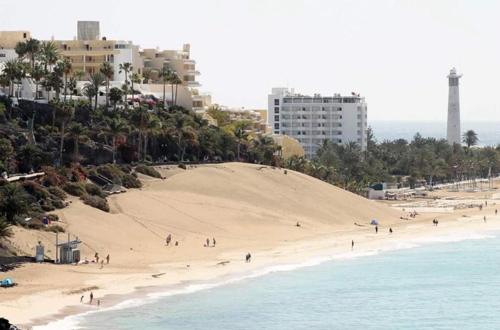 a beach with a bunch of people on it at Jandia Arena Habitación con baño - aire acondicionado in Morro del Jable