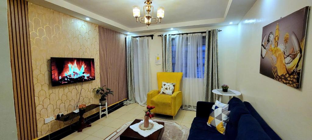 a living room with a blue couch and a yellow chair at GoldenSpark Homes in Thika
