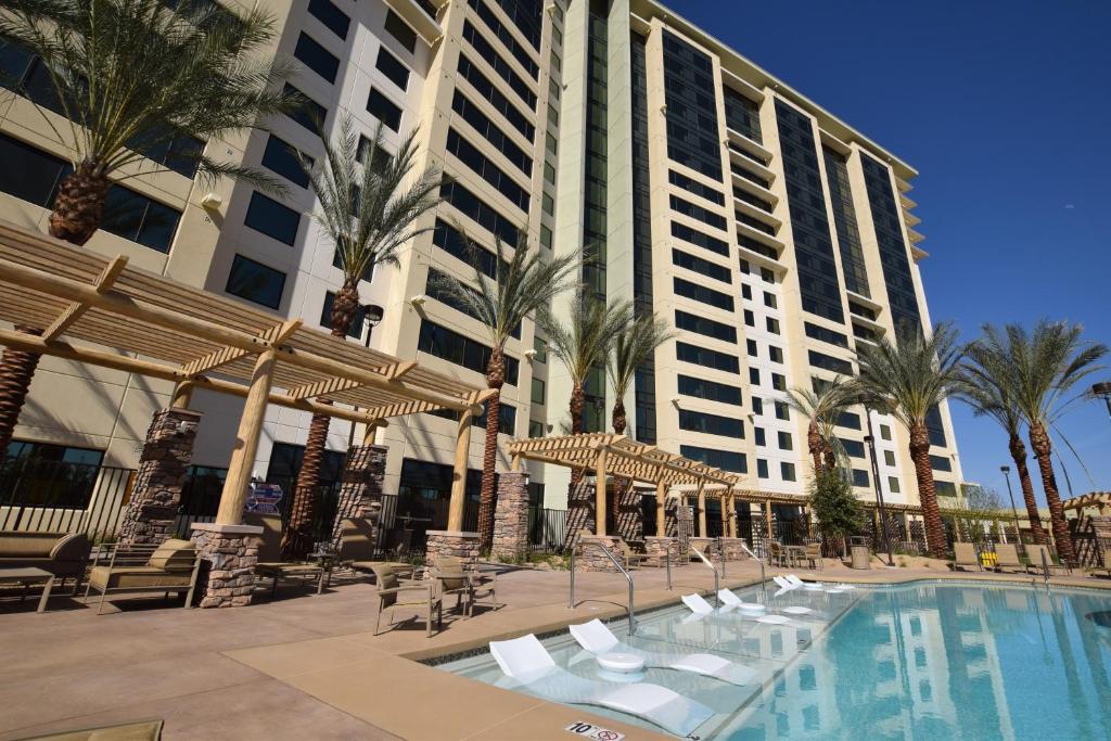 un complexe avec une piscine, des palmiers et un bâtiment dans l'établissement The Berkley, Las Vegas, à Las Vegas