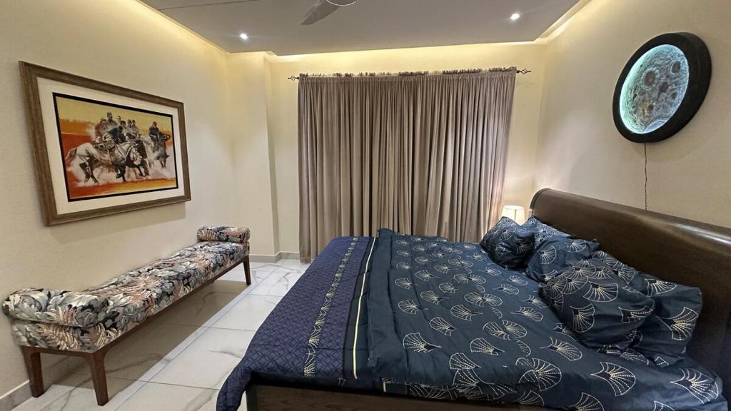 a bedroom with a bed and a couch at Luxury cozy studio apartment with balcony in Lahore