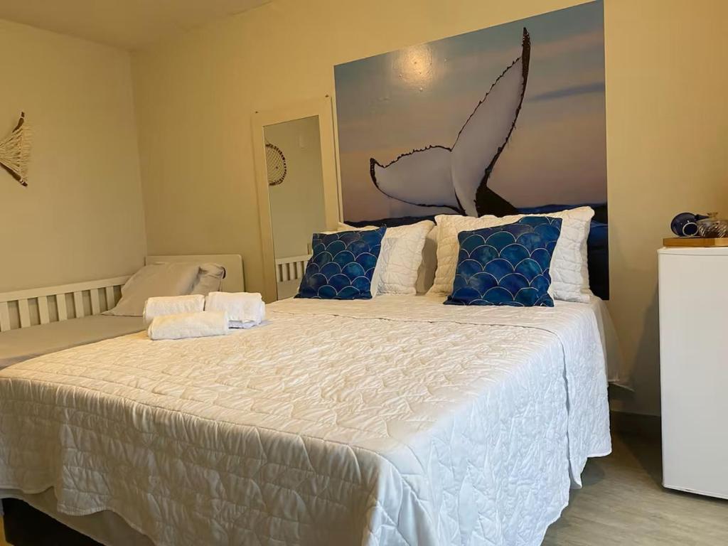Un dormitorio con una cama grande con almohadas azules. en Pousada dos Sonhos Costa Azul, en Rio das Ostras