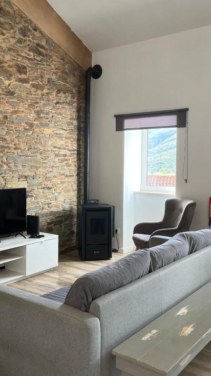 VerdelhosLugar da Borralheira的带沙发和砖墙的客厅