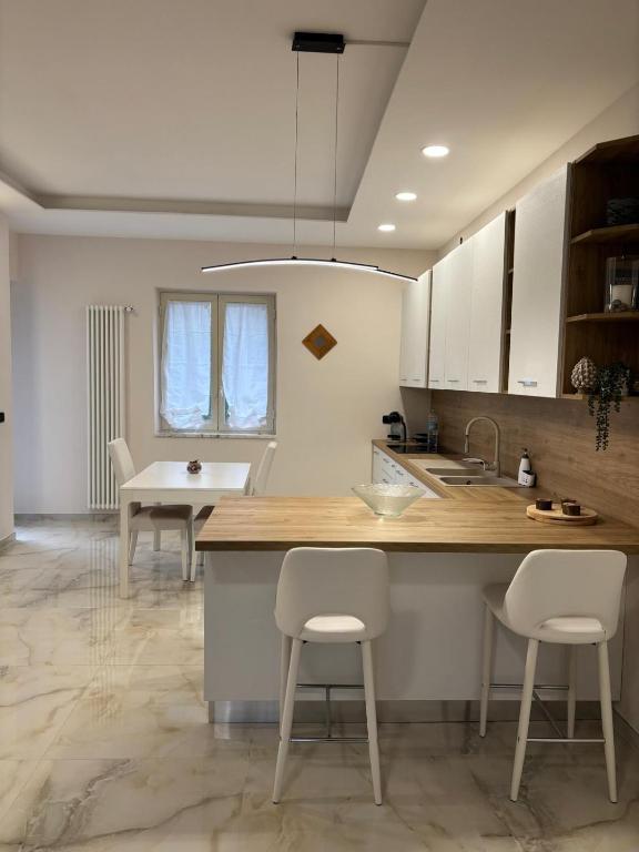 a kitchen with white cabinets and a table and chairs at a&g partenope in Monterusciello
