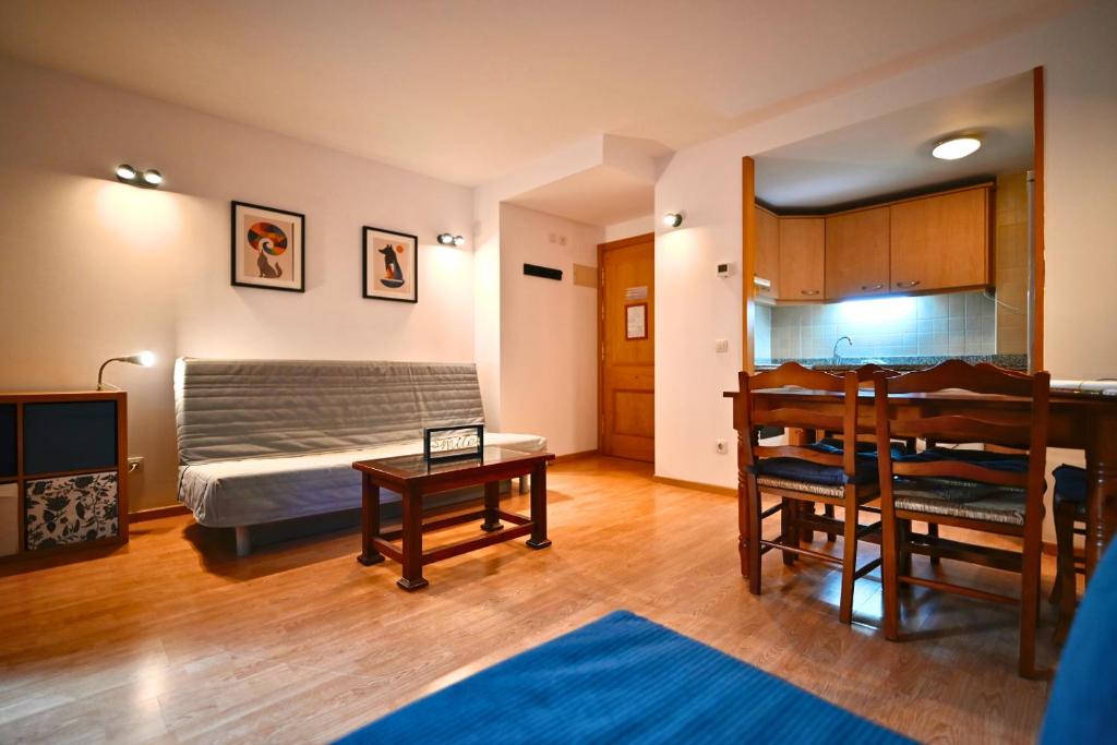 a living room with a bed and a table at Escapada de esquí I Cerca de Grandvalira con Parking in Soldeu