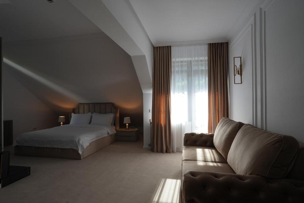 a hotel room with a bed and a couch at Infinity Villa in Predeal