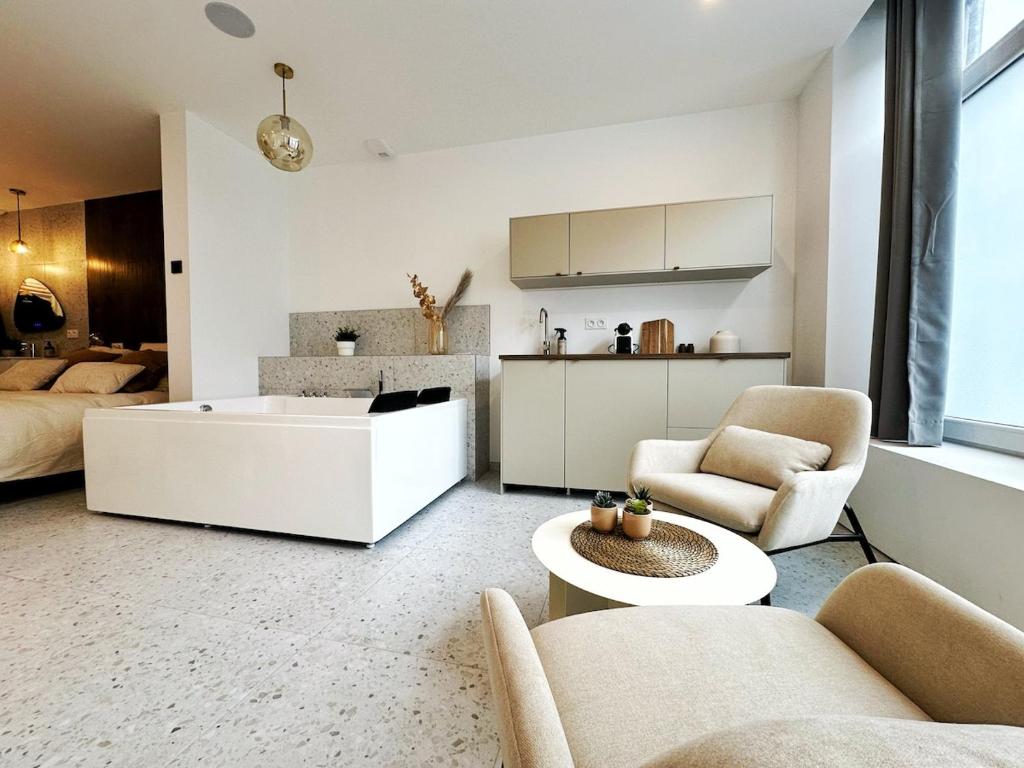 ein Wohnzimmer mit Sofa und Tisch in der Unterkunft L'intemporel - Balneo, Cozy, Romantic in Lambersart