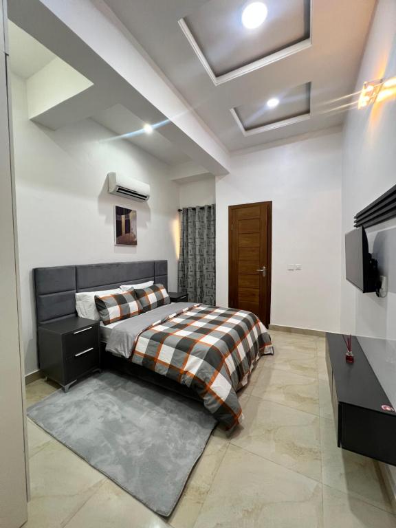 a bedroom with a bed and a flat screen tv at Haven Place in Lekki