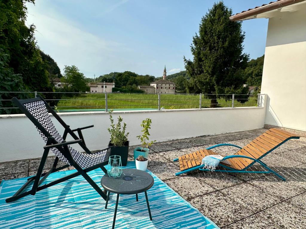 a patio with a table and a chair next to a pool at Appartamento Da Deki con ampio terrazzo vista Monte Grappa in Liedolo