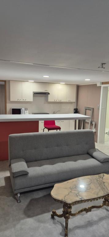 una sala de estar con un sofá y una mesa en Rué de Rome, en Lucé
