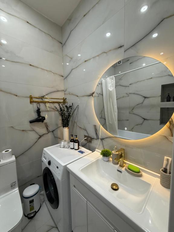 a bathroom with a sink and a washing machine at С Видом на Горы Квартира возле ТРЦ Mega Center in Zhezdi