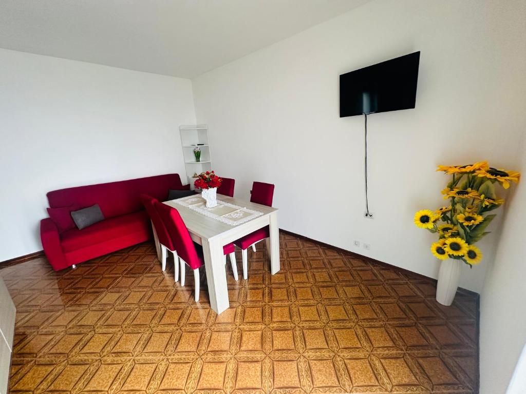 a living room with a table and a red couch at sole in Novara