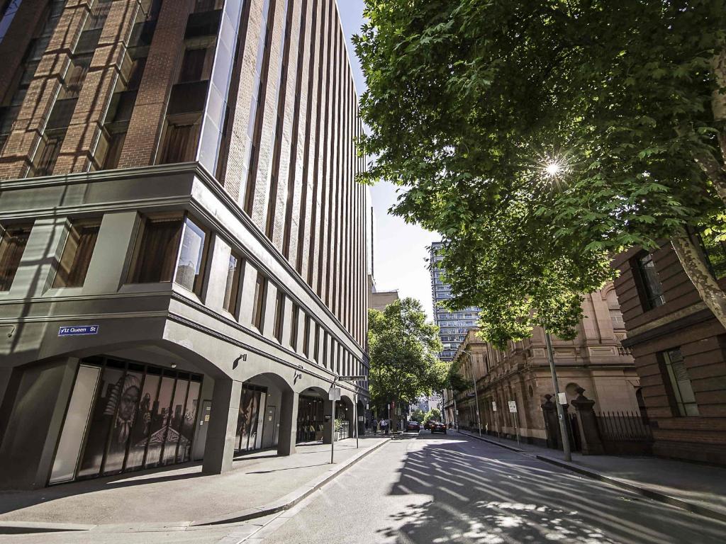 an empty city street with a tall building at Mantra on Little Bourke Melbourne in Melbourne
