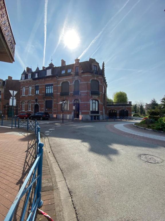 un bâtiment avec une clôture bleue en face d'une rue dans l'établissement Halluin Marthe Nollet, à Halluin