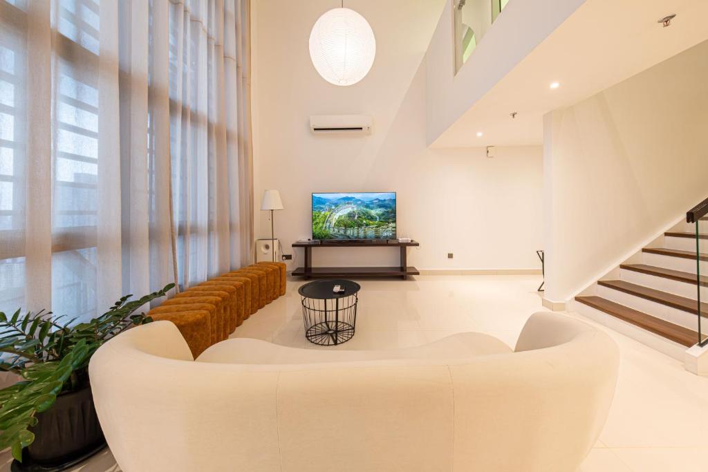 a living room with a couch and a tv at La Gente x Novo Ampang 3r3b Duplex High Floor in Kuala Lumpur