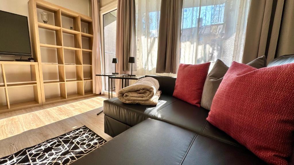 a living room with a black couch and red pillows at Lindenhof Apartment 13 in Bad Aibling