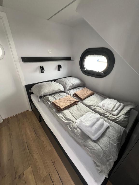 a bed in a small room with a window at Houseboat Zegrze in Zegrze Południowe